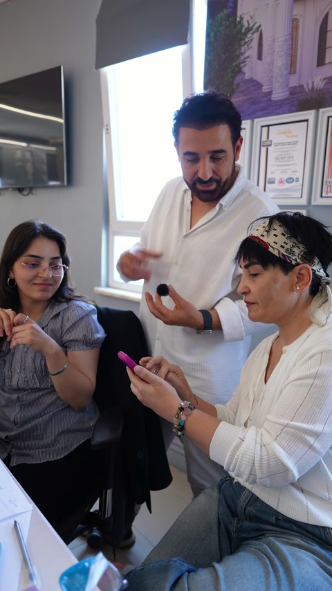 Selda Hanım telefondaki özel tasarım çalışmalarını ekibe gösteriyor