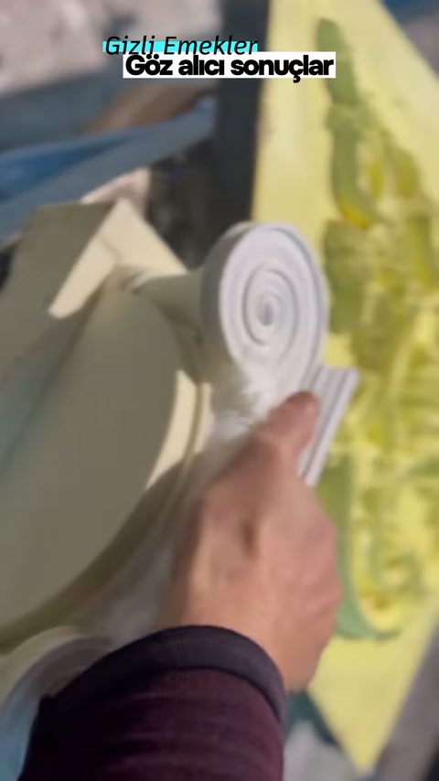 Parmak, başlığın üst volütü yanındaki kabartma çizgisini gösteriyor
