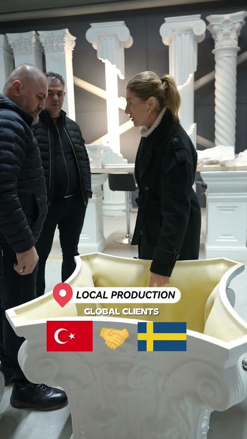 Beyaz kabartmalı dekoratif elemanın biçimi ziyaretçilerle birlikte değerlendiriliyor