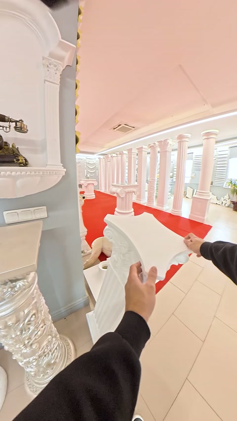 Kabartmalı başlık parçası kırmızı halı önünde iki elle tutuluyor