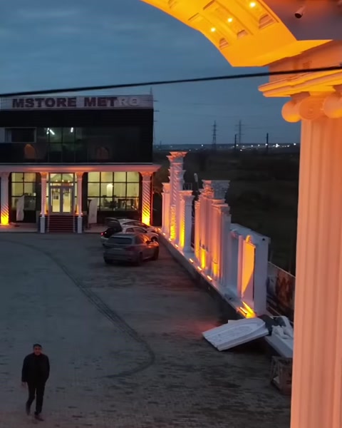Ticari yapıya uzanan yol boyunca sıralanan aydınlatmalı cephe elemanları
