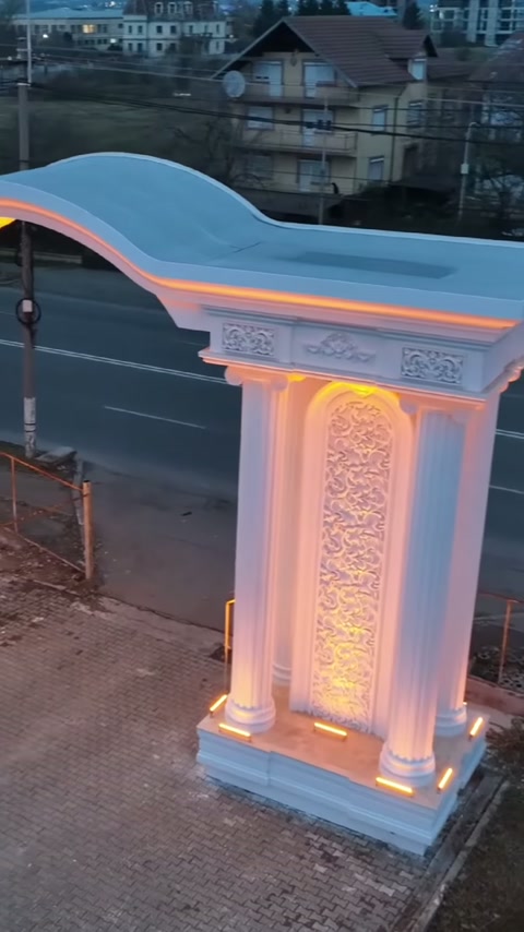 Kabartmalı orta pano, ikili sütunlar ve kıvrımlı kemer altında aydınlatılıyor