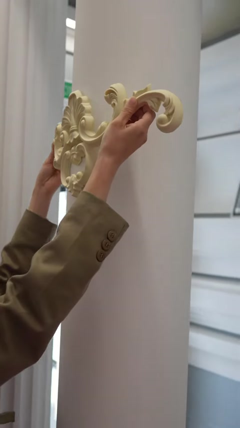 Motifin kıvrımlı kenarları sütun yüzeyine dikkatlice bastırılıyor