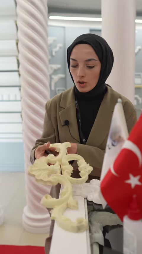 Açık sarı motif modeli iki elle kavranıp masadan kaldırılıyor