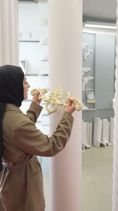 Sunucu dekoratif parçayı sütuna yerleştirmeden önce iki ucundan tutuyor