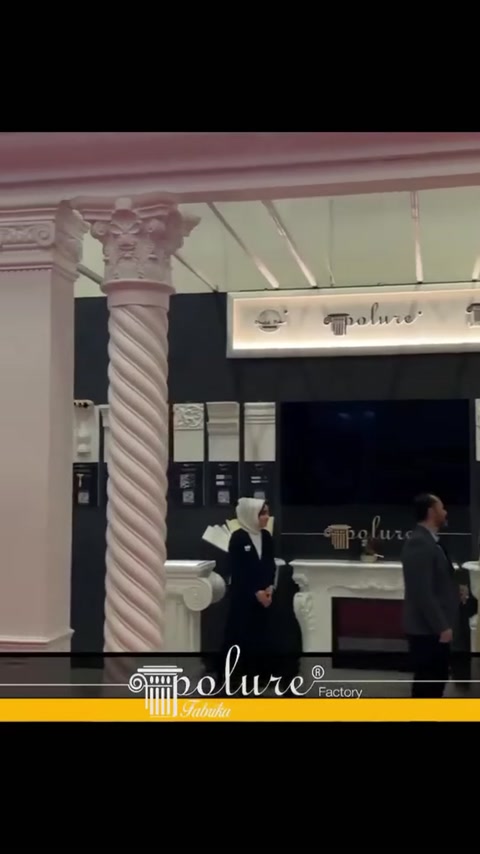 Burmalı ve yivli dekoratif sütunlarla çerçevelenen fuar standı girişi