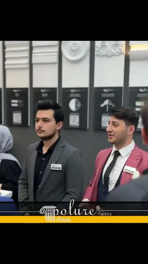 İki stand görevlisi, kabartmalı pano numunelerinin önünde sohbet ediyor