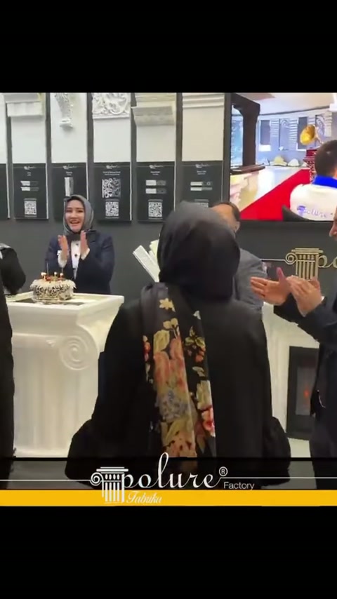 Teşhir masasındaki pasta çevresinde stand ekibi alkışlarla buluşuyor