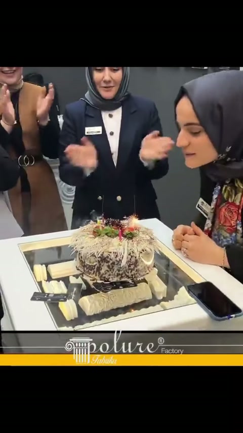 Çıta numuneleriyle çevrili pasta, kutlama sırasında masada sergileniyor