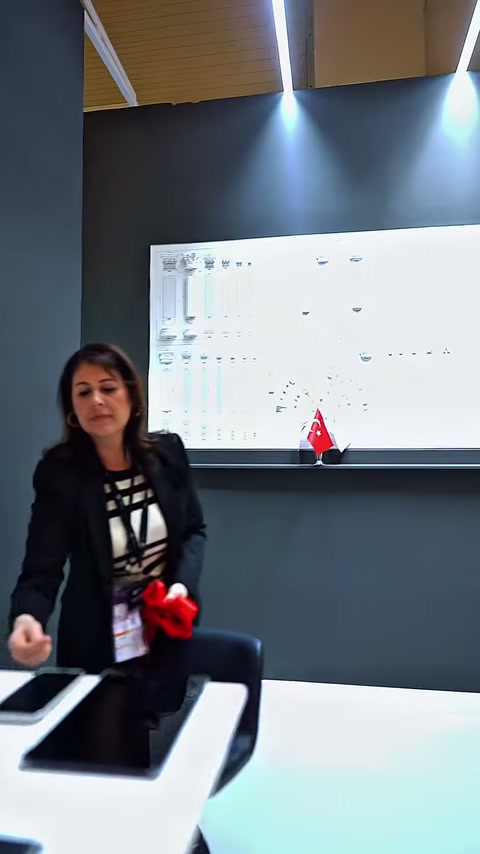 Fuar görevlisi, numune panosu önünde masa düzeniyle ilgileniyor