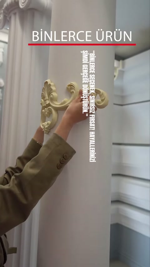 Showroom duvarındaki altın renkli bezemeli konsol detayı elle inceleniyor