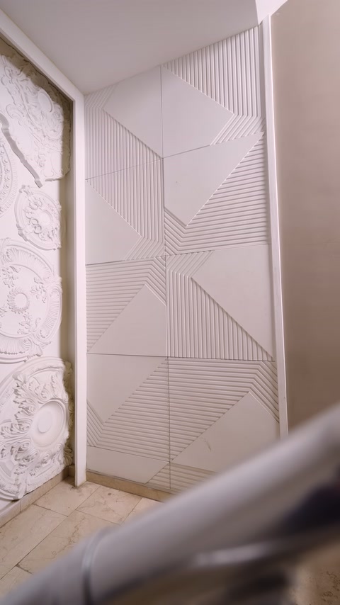 Açık renkli kare paneller, merdiven duvarını geometrik desenlerle kaplıyor
