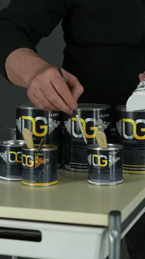 Usta çalışma tezgâhında fırçasını boyaya yeniden batırıyor