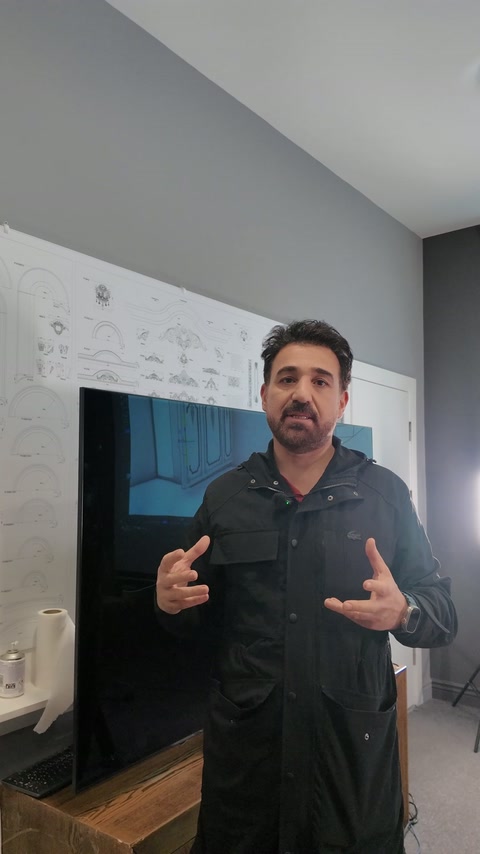 Projeksiyonda merdivenli iç mekân modeli gösterilirken sunucu yanında duruyor.