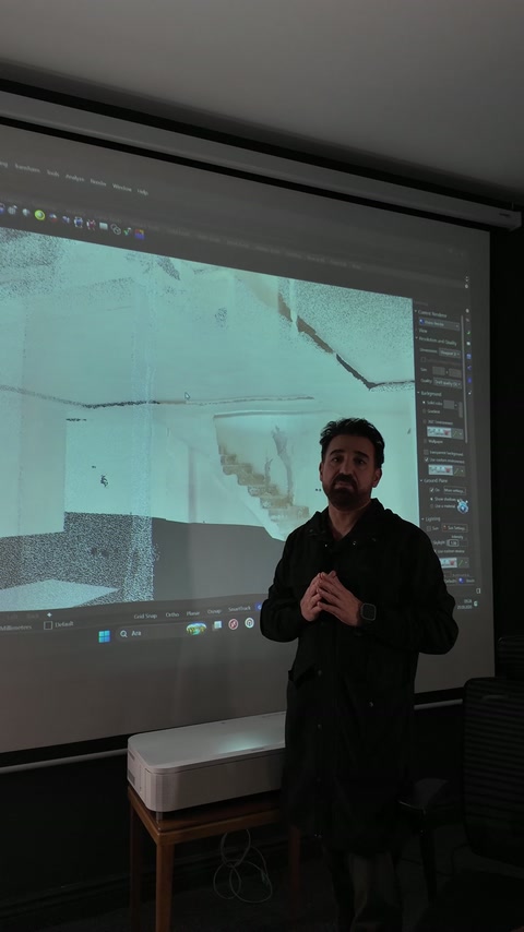 Sunucu, büyük ekrandaki taranmış iç mekân görünümünü izleyicilere anlatıyor.