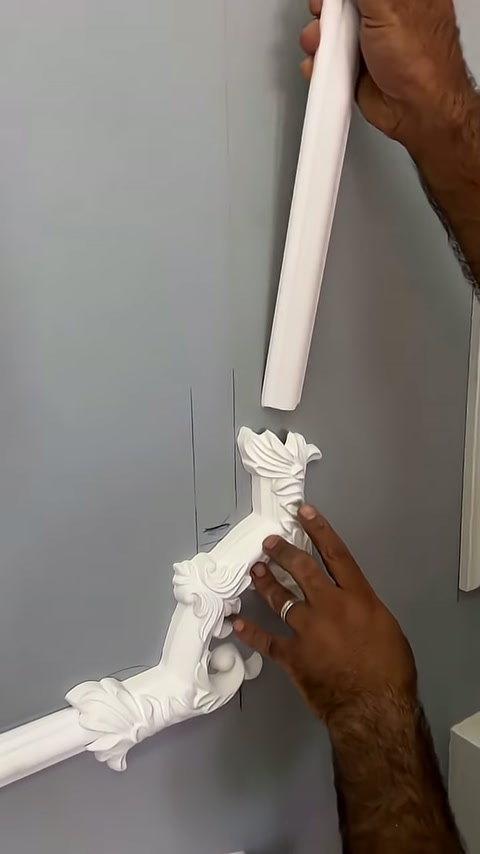 Usta üstteki beyaz çıtayı uzun süs elemanına yaklaştırıyor
