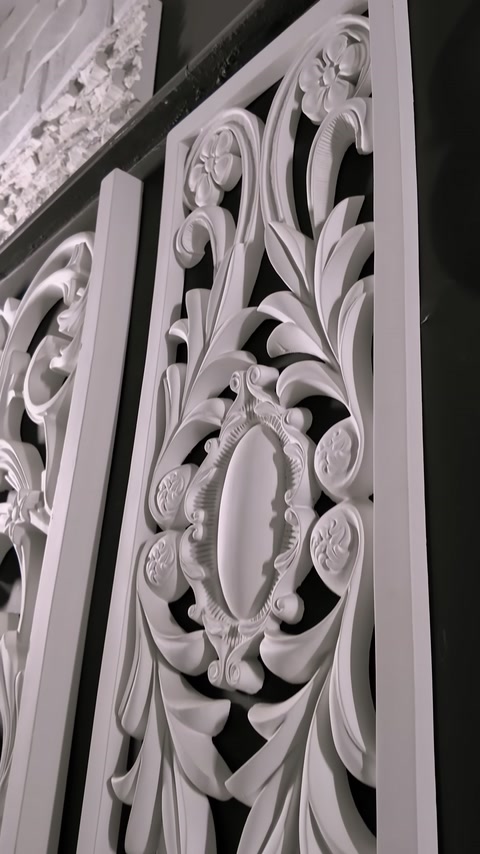 Yaprak kıvrımları ve madalyonlarla bezeli dekoratif panel detayları