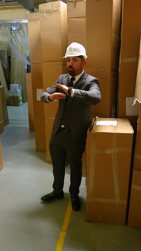 Baretli görevli, paketlerle çevrili kontrol noktasında açıklama yapıyor.