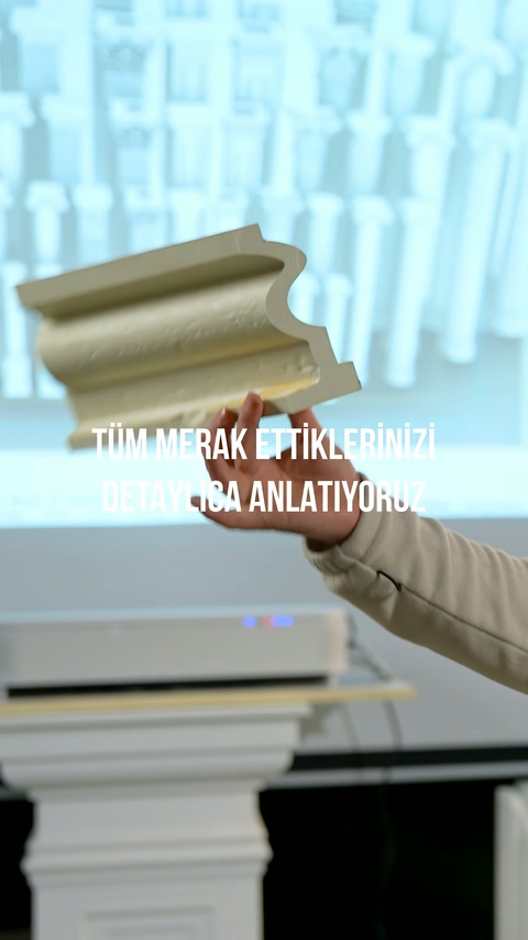 Oyma biçimli küçük süs profili usta tarafından havada tutuluyor