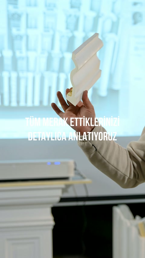 Kesilmiş dekoratif profil numunesinin kıvrımlı kesiti kameraya gösteriliyor