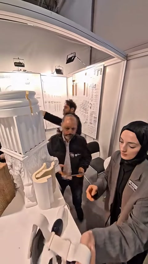 Ziyaretçiler, farklı profilleri ve sütun tasarımlarını standda inceliyor.