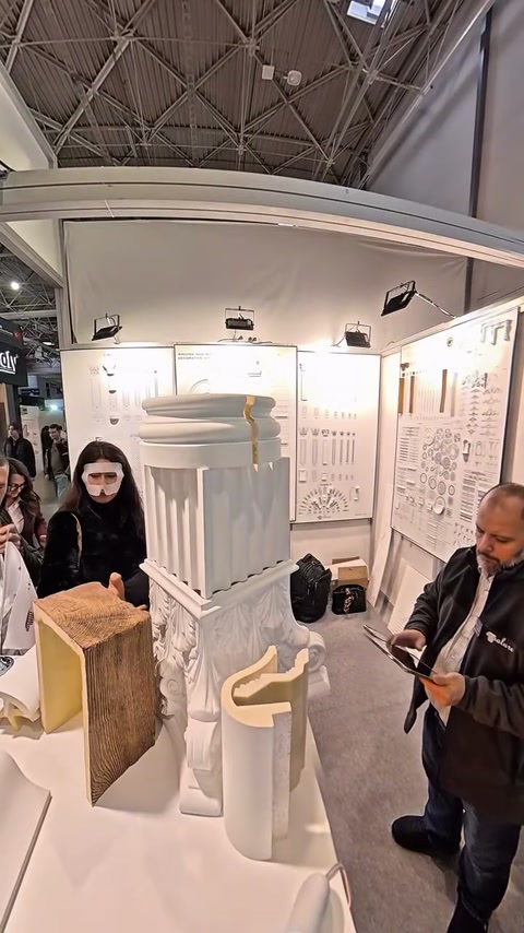 Sütun maketi çevresinde ziyaretçiler ürünleri dikkatle değerlendiriyor.