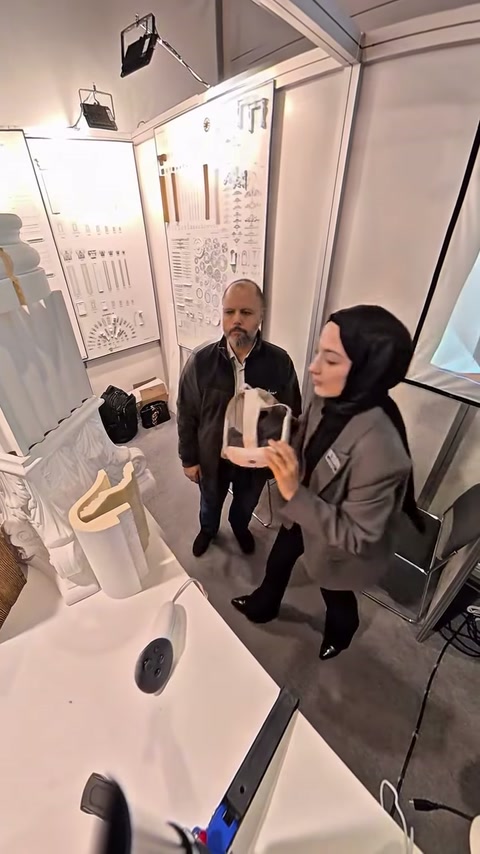 Ziyaretçiler, stand görevlisinden dekorasyon ürünleri hakkında bilgi alıyor.