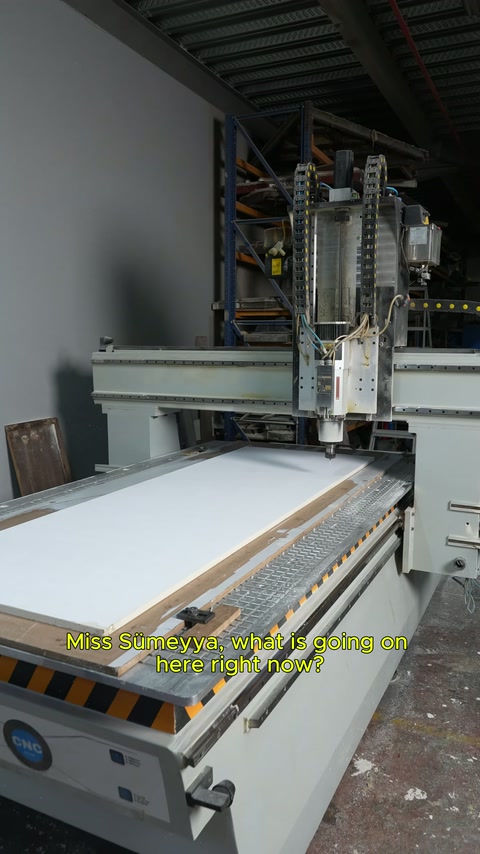 CNC tezgâhının önünde çalışan, makinenin işleyişini açıklamaya başlıyor