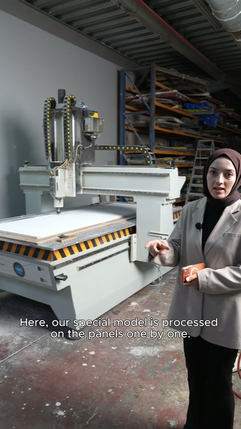 Kesici ünitelerin önünde duran çalışan, işleme sürecini anlatıyor