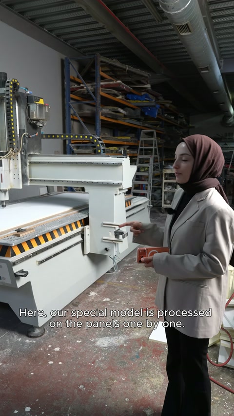 CNC makinesinin yanında çalışan, üretim detaylarını kameraya aktarıyor