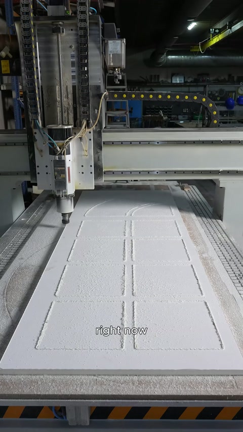 Beyaz panel, CNC tablası üzerinde kesim çizgileriyle işlenmiş halde duruyor