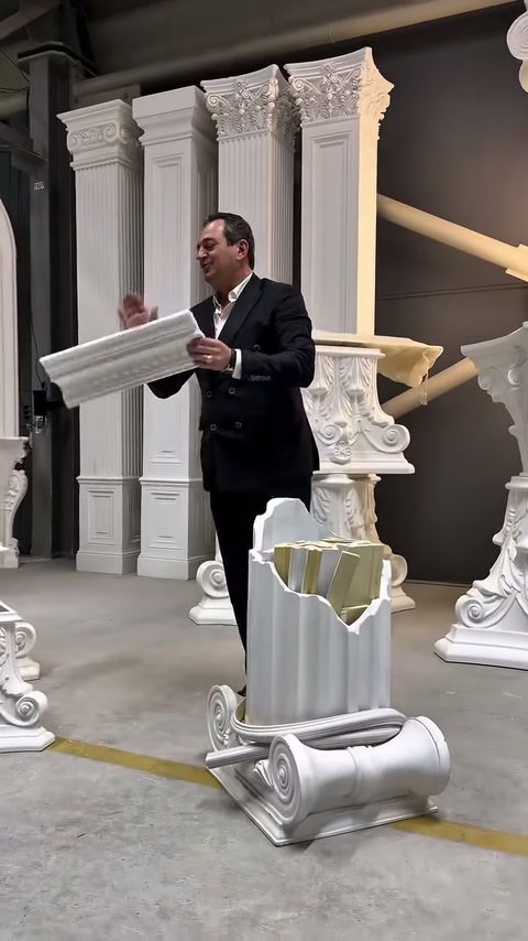 Uzun beyaz dekoratif profil, klasik sütun modelleri önünde yatay tutuluyor