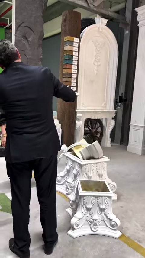 Müşteri, uzun dekoratif parçayı dikey renk örneklerinin önünde gösteriyor
