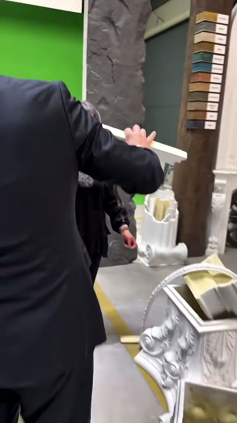Müşteri, dekoratif çıtayı sergilenen işlemeli kaideye doğru uzatıyor