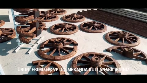 Farklı boyutlu rustik tekerler açık alandaki ürün düzeninde sunuluyor.
