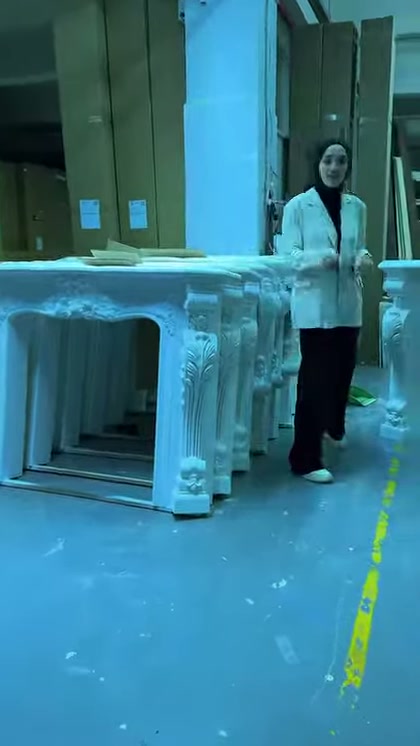 Atölyede sunucunun yanında kabartmalı hazır şömine çerçeveleri sergileniyor