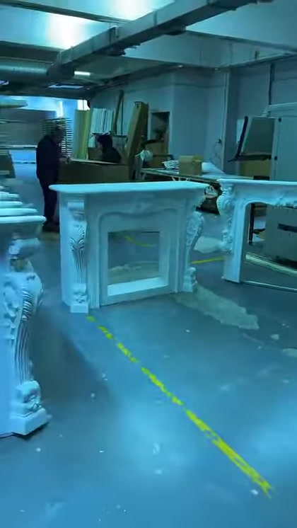 Birden fazla beyaz şömine çerçevesi üretim bölümünde aralıklı duruyor