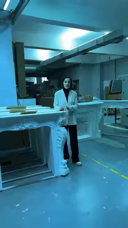 Sunucu sıralanan şöminelerin önünde klasik çerçeve tasarımını anlatıyor
