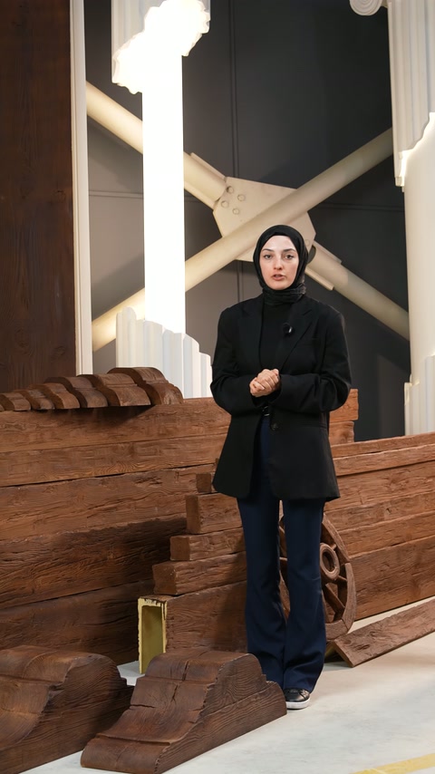 Sunucu, ahşap dokulu payandalar önünde ürün özelliklerini açıklıyor