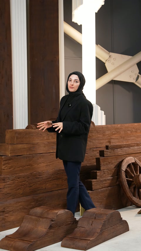 Ahşap efektli uzun parçalar, sunucunun arkasında katmanlı sergileniyor