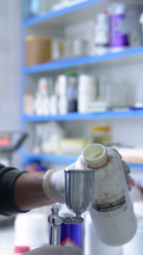 Uzman, püskürtme ekipmanının metal kabını sıvı malzemeyle tamamlıyor