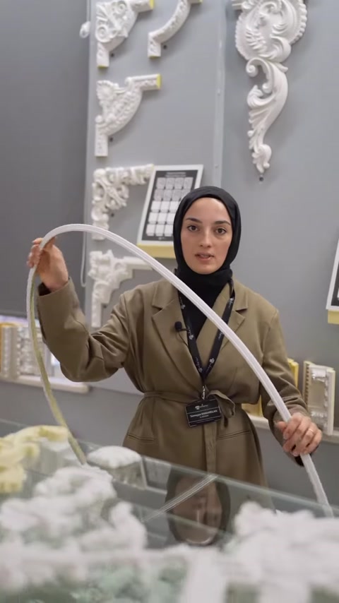 Beyaz flex çıta iki elle geniş bir kemer biçiminde bükülüyor.