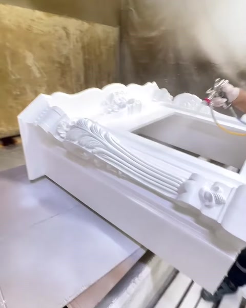 Tezgâhtaki beyaz şömine çerçevesi kabartmalı bezemeleriyle bütünüyle görülüyor.