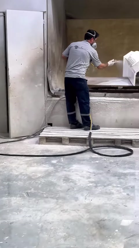 Üretim kabininde dekoratif şömine gövdesini boyayan çalışan görülüyor