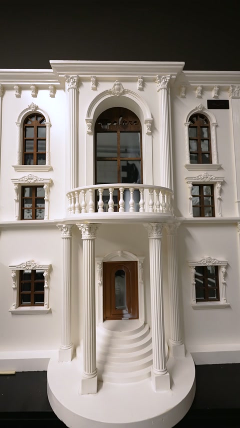 Kemerli pencereler, sütunlar ve korkuluklu balkon içeren cephe modeli sergileniyor.