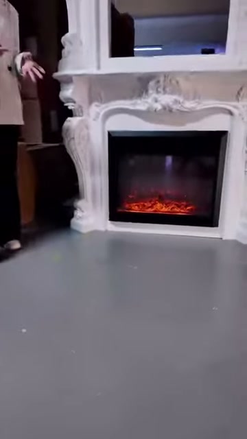 Kırmızı kor görünümü şömine çerçevesinin siyah iç bölümünü aydınlatıyor