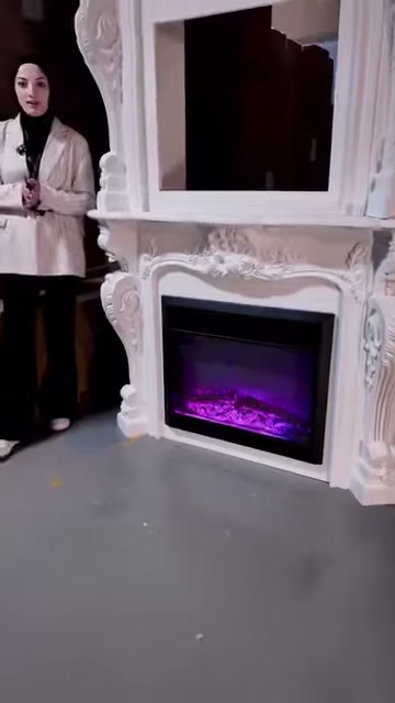 Sunucu mor ışıklı şöminenin yanında ayakta açıklama yapıyor