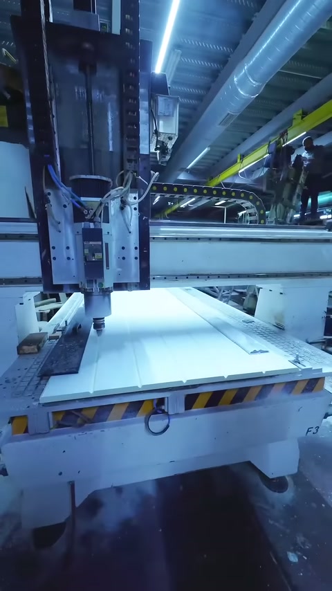 İşleme tablasındaki beyaz panel ve dikey kesici ünite görüntüleniyor