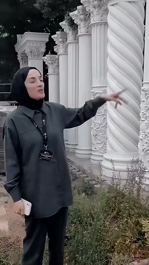 Sunucu, sarmal gövdeli sütunun yüzeyini eliyle işaret ediyor.