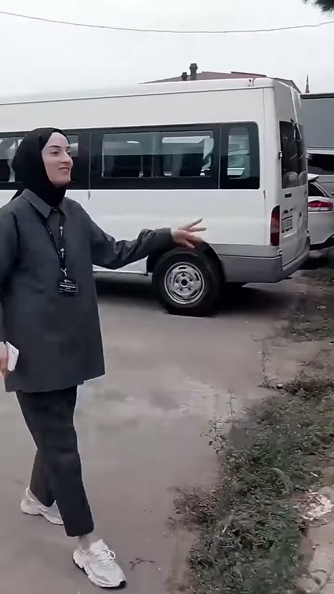 Sunucu, park halindeki aracın önünden sütunlu yapıya ilerliyor.
